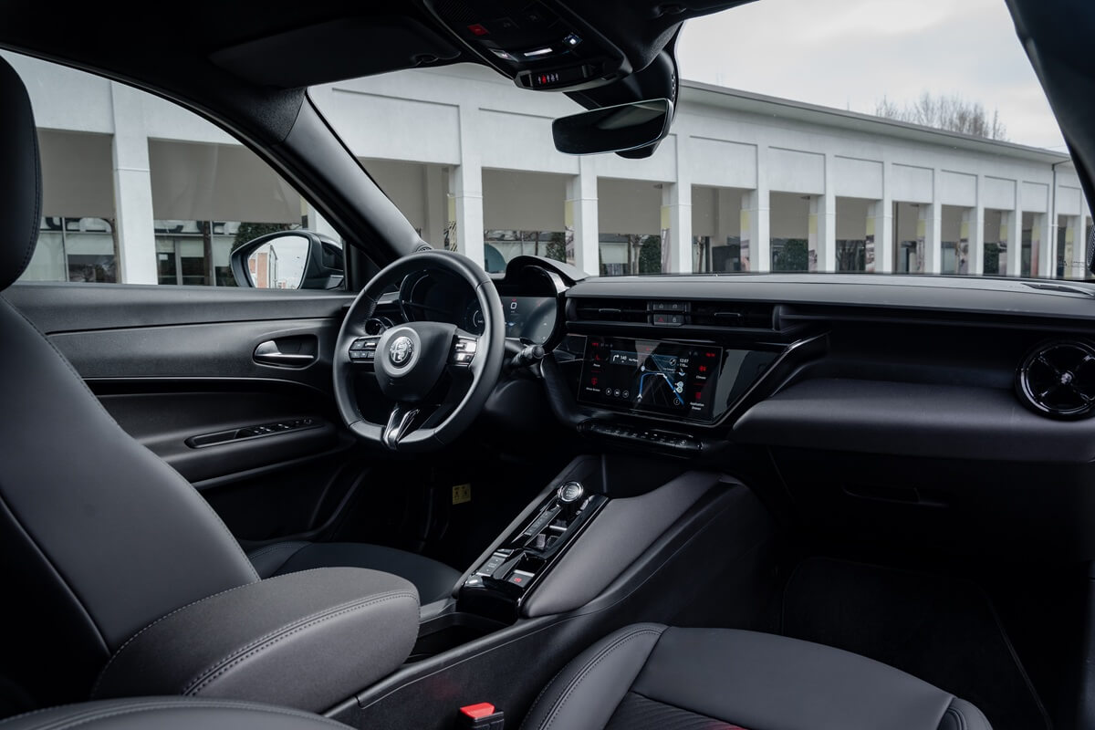 Intérieur de l’Alfa Romeo Junior Ibrida avec volant, écran conducteur et écran d’infodivertissement
